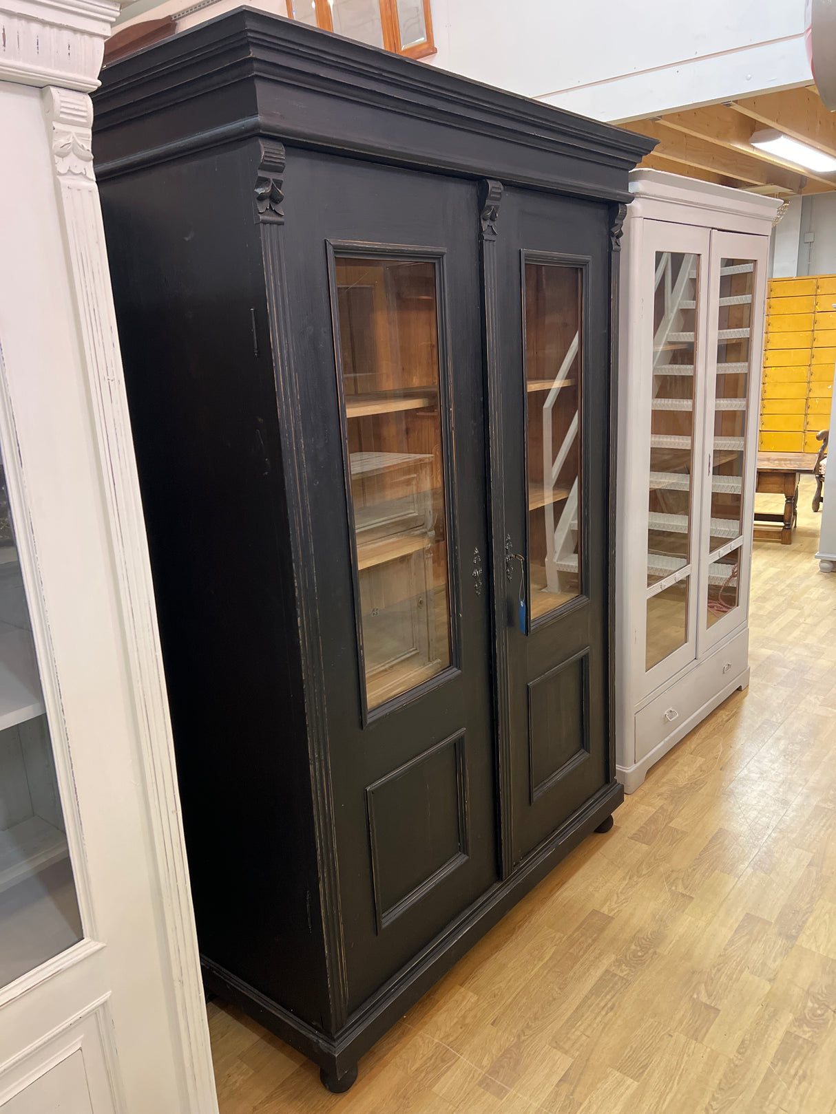 Stylish black antique display cabinet. W. 131cm, D. 57cm, H. 190.5cm.
