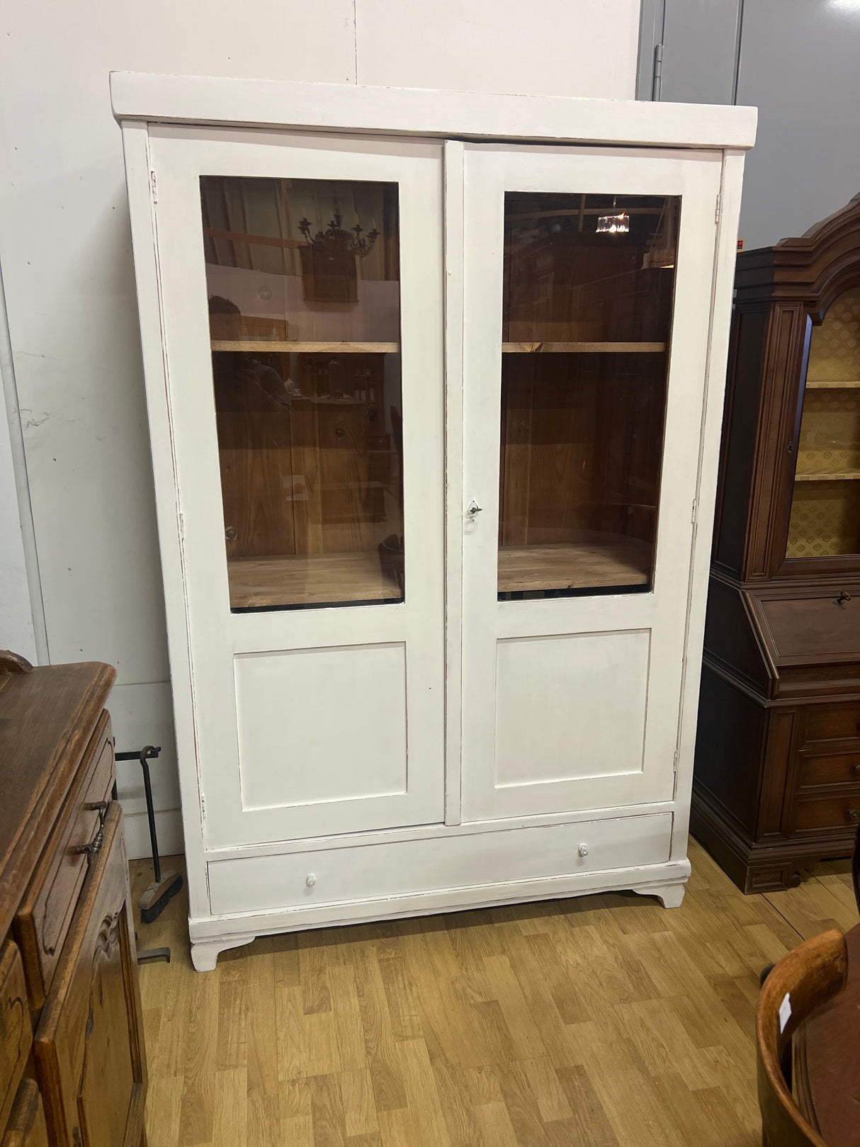 Valkoinen vitriinikaappi L. 132,5cm, S. 51cm ja K. 198cm.