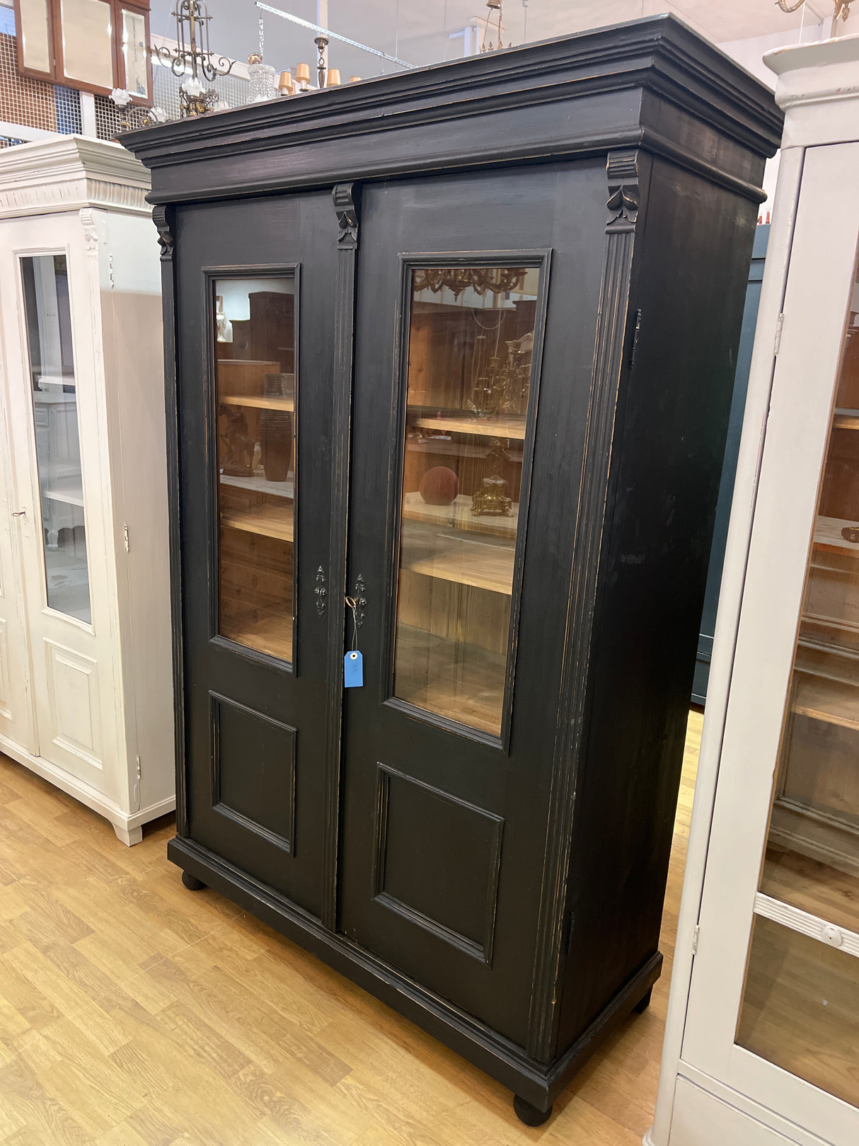 Stylish black antique display cabinet. W. 131cm, D. 57cm, H. 190.5cm.